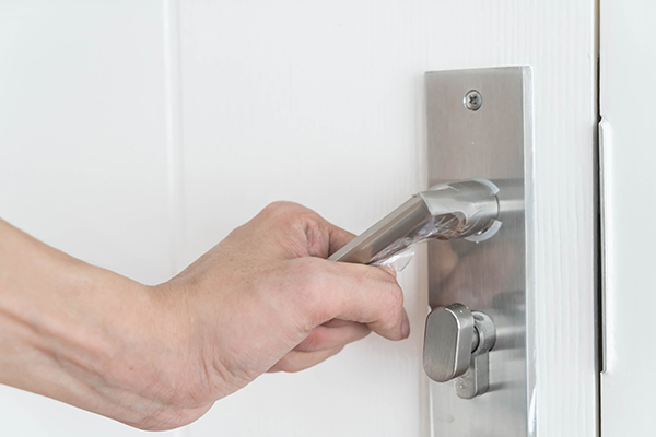 Image showing someones hand on a door handle opening it